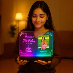 Person holding a colorful LED sign with a photo and text